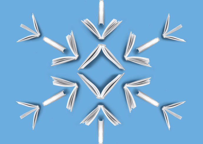 A view from above of opened books arranged to create the shape of a snowflake.
