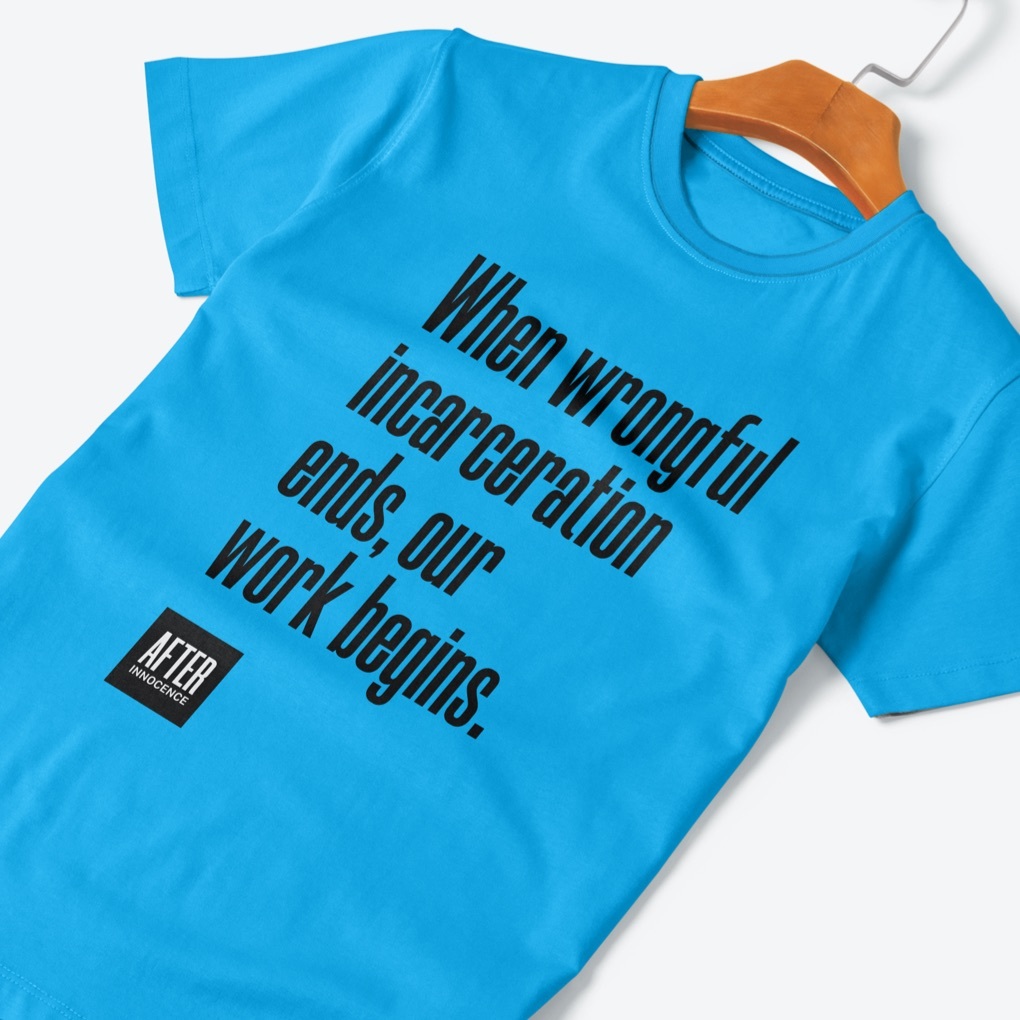 A blue t-shirt with the After Innocence logo and slogan in large print: when wrongful imprisonment ends, our work begins.