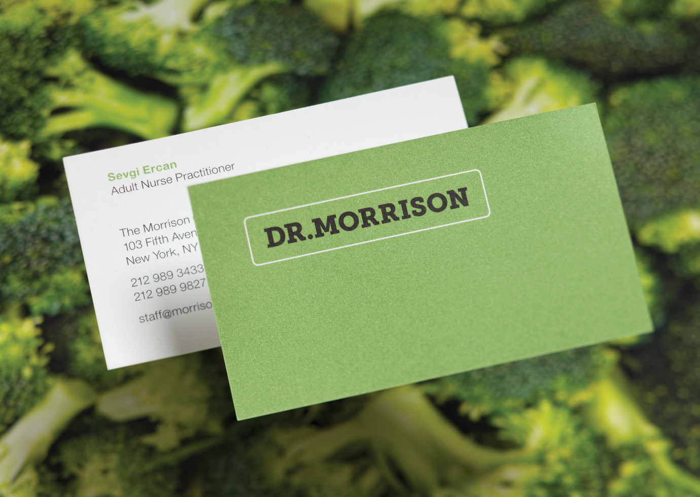Both sides of a Dr. Morrison business card with the company logotype against blurred image of broccoli florets.