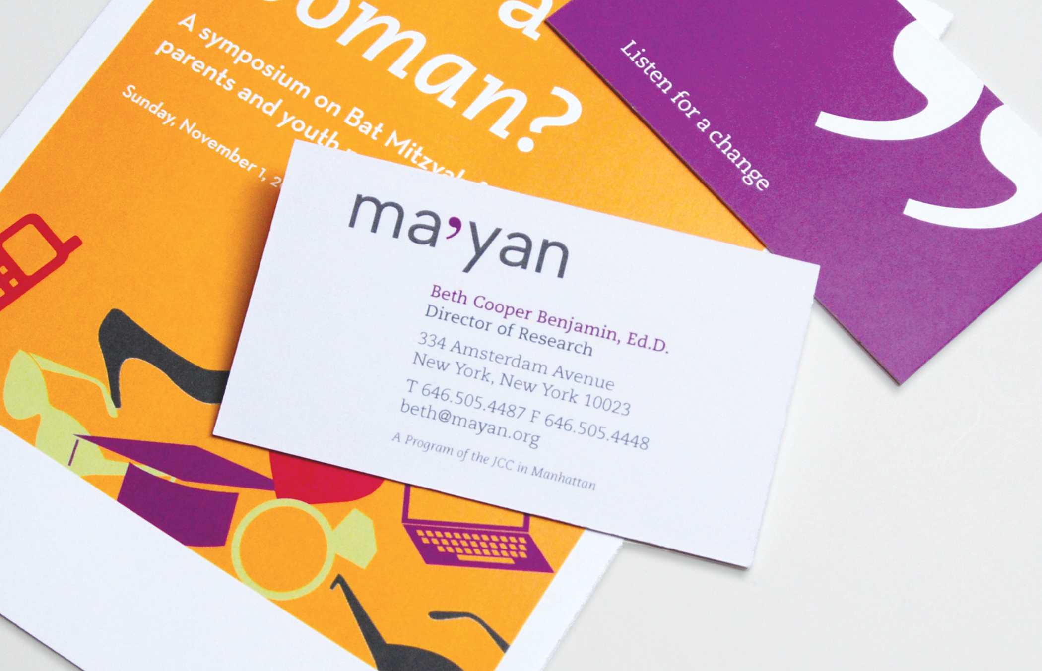 The front of Ma'yan business card on top of colorful orange and purple paper informational materials.
