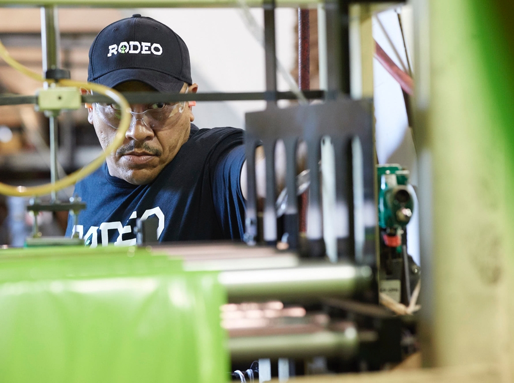 A worker in a Rodeo Plastics tee shirt and cap operates machinery in the company's Mesquite Texas factory.
