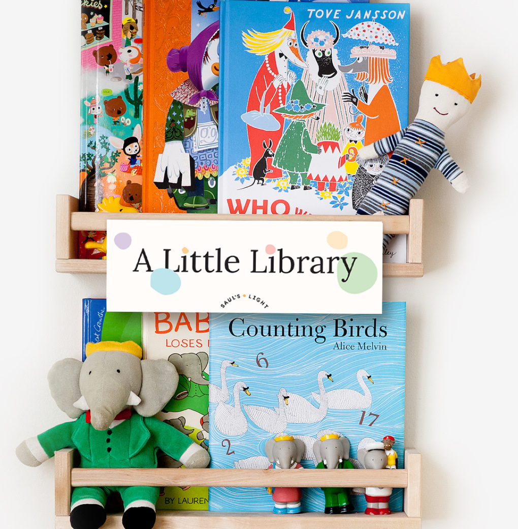 A Saul's Light Little Library stand, with illustrated children's book and plush character toys.