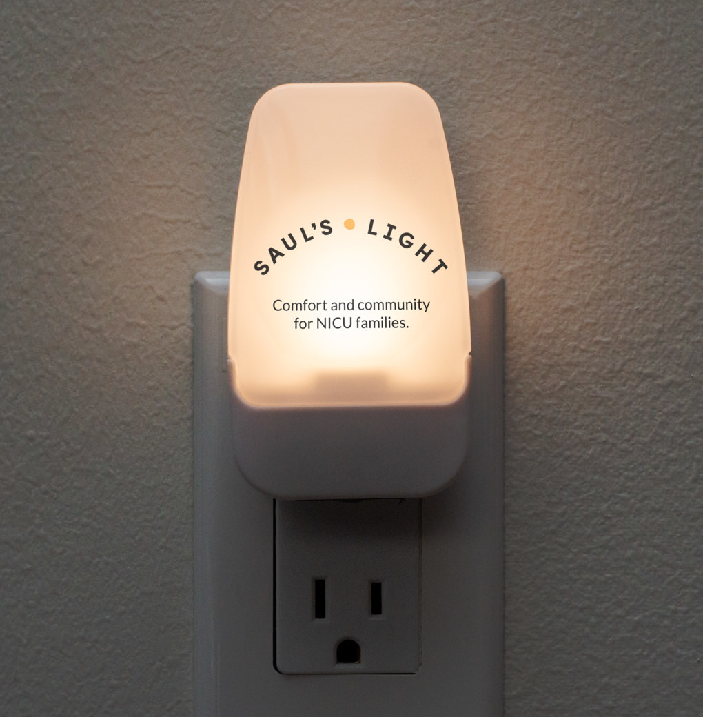 A Saul's Light nightlight printed with the foundation's logo and the phrase, Comfort and community for NICU families.