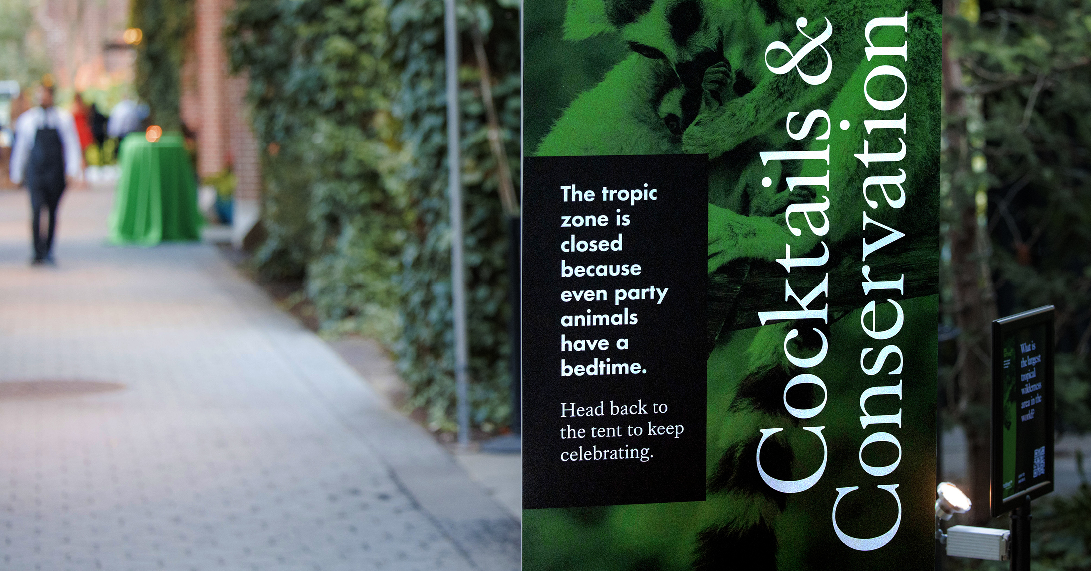 Close up of a large vertical outdoor sign for Redd Positive Cocktails and Conservation launch event letting guests know that the tropic zone exhibit is now closed.